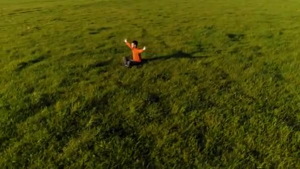 Lage hoogte radiale vlucht over sport yoga man op perfect groen gras. Zonsondergang in de bergen. — Stockvideo