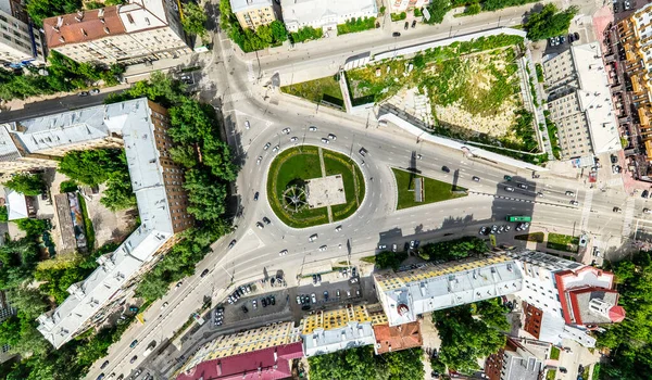 Vista aérea de la ciudad con encrucijadas y caminos, casas, edificios, parques y estacionamientos. Imagen panorámica soleada de verano —  Fotos de Stock