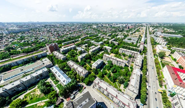 Letecký výhled na město s křižovatkou a silnic, domů, budov, parků a parkovišť. Slunečné léto panoramatický obraz — Stock fotografie