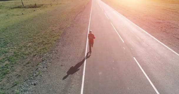 Volo a bassa quota di fronte all'uomo sportivo in perfetta strada asfaltata — Video Stock