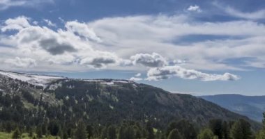 Dağların arkasındaki bulutların zaman çizelgesi. Kar, kayalar, uçurumlar ve derin mavi gökyüzü. Yüksek irtifa.