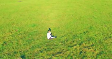 Yeşil çimlerin üzerinde sarı kırsal alanda not defteri olan bir adamın etrafında alçak yörünge uçuşları..