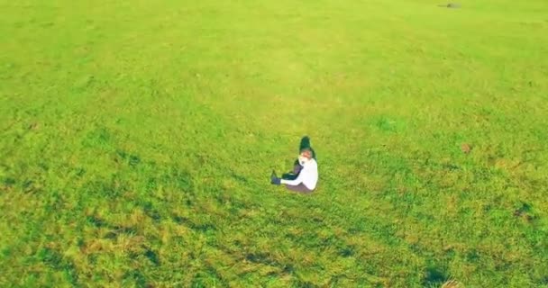 노란색 시골 들판에 노트북 패드가 있는 푸른 잔디 위에서 사람 주위를 낮은 궤도 비행. — 비디오