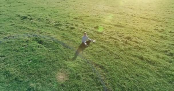 Basso volo orbitale intorno all'uomo su erba verde con blocco note al campo rurale giallo. — Video Stock