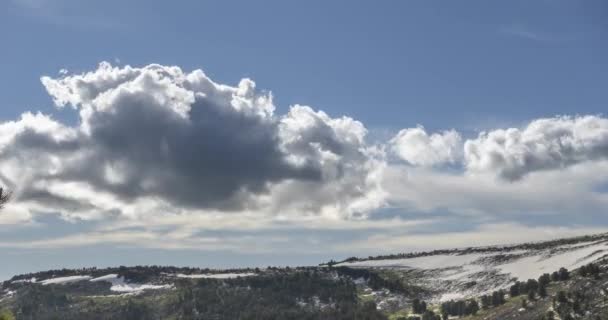 Time lapse de paysage nuageux derrière le sommet des montagnes. Neige, rochers, falaises et ciel bleu profond. Haute altitude.