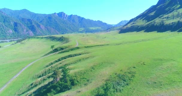 Camino de montaña rural aéreo y prado en la soleada mañana de verano. Autopista del asfalto y río. — Vídeo de stock