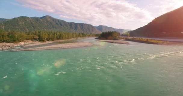 4k UHD hava görüntüsü. Güneşli yaz sabahında taze soğuk dağ nehri üzerinde alçak uçuş. Horisont 'ta yeşil ağaçlar ve güneş ışınları — Stok video