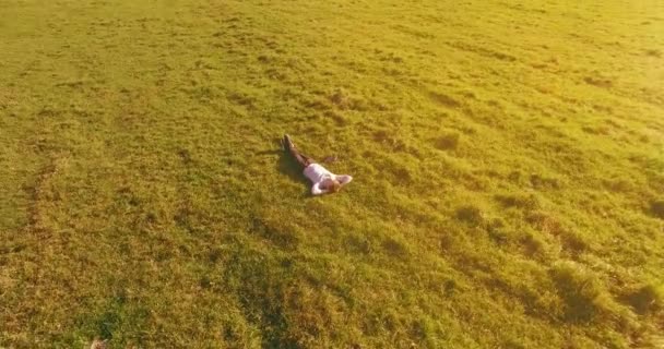 Vôo orbital baixo em torno do homem na grama verde com bloco de caderno no campo rural amarelo. — Vídeo de Stock