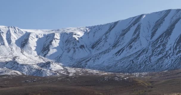 Timelapse del movimento del sole sul cielo cristallino sopra la cima della montagna della neve. Erba gialla al prato autunnale. Selvaggia natura infinita. — Video Stock