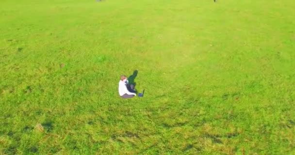 Basso volo orbitale intorno all'uomo su erba verde con blocco note al campo rurale giallo. — Video Stock