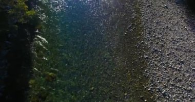 Güneşli yaz sabahında kayalarla birlikte taze, hızlı dağ nehri üzerinde alçak irtifa uçuşu..