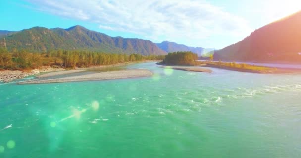 Vista aérea 4k UHD. Vuelo bajo sobre el río fresco de montaña fría en la soleada mañana de verano. Árboles verdes y rayos de sol en horisont — Vídeos de Stock