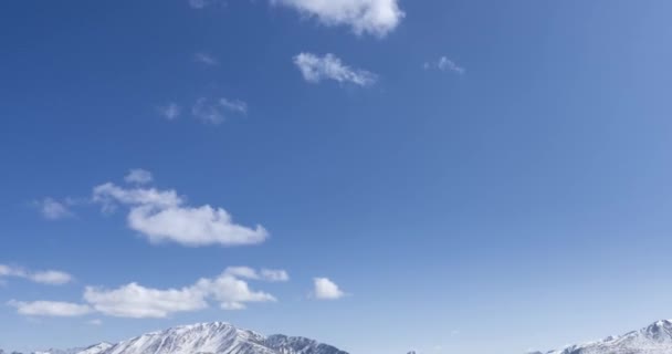 Timelapse del movimento del sole sul cielo cristallino con nuvole sopra la cima della montagna della neve. Erba gialla in autunno prato ad alta quota. Selvaggia natura infinita. — Video Stock