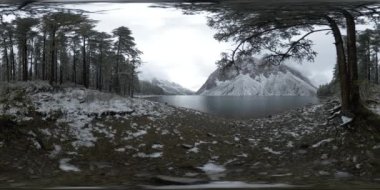 Dağ Gölü, kışın 360 Vr. Vahşi doğa ve dağ vadisi. Çam ağaçlarından yeşil orman ve gökyüzünde hızlı bulutlar.