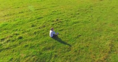 Yeşil çimlerin üzerinde sarı kırsal alanda not defteri olan bir adamın etrafında alçak yörünge uçuşları..