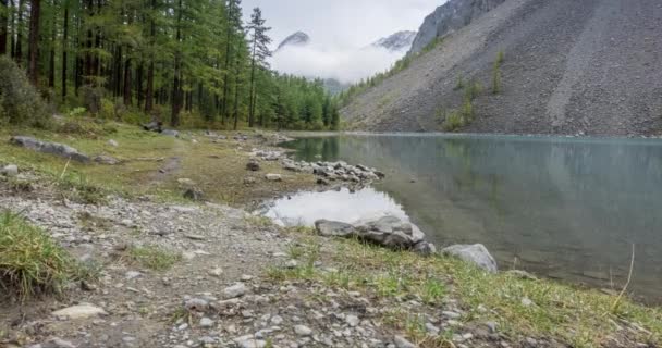 Bergsee-Zeitraffer zur Sommer- oder Herbstzeit. Wilde Natur und ländliches Bergtal. Grüner Kiefernwald und schnelle Wolken am Himmel. Motorisierte Schiebereglerbewegung — Stockvideo