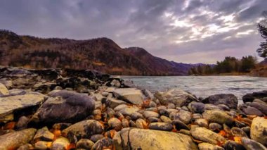 Zaman atlamalı bir nehir dağ orman kenarında bir kadeh. Büyük kayalar ve hızlı bulutlar movenings. Yatay kaydırıcı hareket