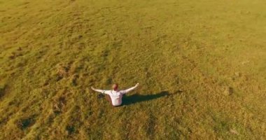 Yeşil çimlerin üzerinde sarı kırsal alanda not defteri olan bir adamın etrafında alçak yörünge uçuşları..