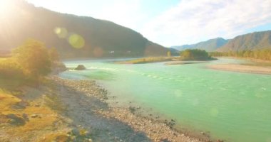 Güneşli yaz sabahında kayalarla birlikte taze, hızlı dağ nehri üzerinde alçak irtifa uçuşu..