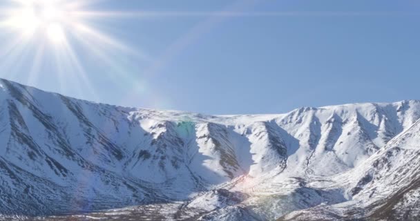 Timelapse van de zon beweging op kristalheldere hemel boven sneeuw bergtop. Gele gras op de herfstweide. Wilde eindeloze natuur. — Stockvideo