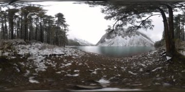 Dağ Gölü, kışın 360 Vr. Vahşi doğa ve dağ vadisi. Çam ağaçlarından yeşil orman ve gökyüzünde hızlı bulutlar.