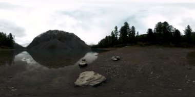 Dağ Gölü 'nün kış zamanı 360 Vr. Vahşi doğa ve dağ vadisi. Çam ağaçlarından yeşil orman ve gökyüzünde hızlı bulutlar.