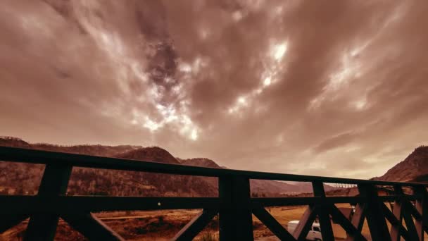 Timelapse drewnianego ogrodzenia na wysokim tarasie w górskim krajobrazie z chmurami. Poziomy ruch suwaka — Wideo stockowe