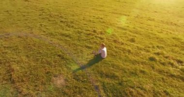 Yeşil çimlerin üzerinde sarı kırsal alanda not defteri olan bir adamın etrafında alçak yörünge uçuşları..