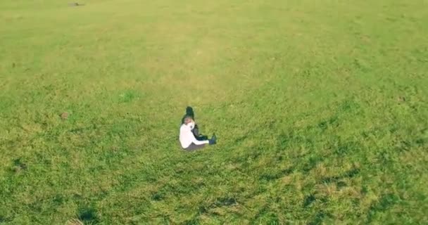 Lage baanvlucht rond mens op groen gras met notitieblok op geel landelijk veld. — Stockvideo