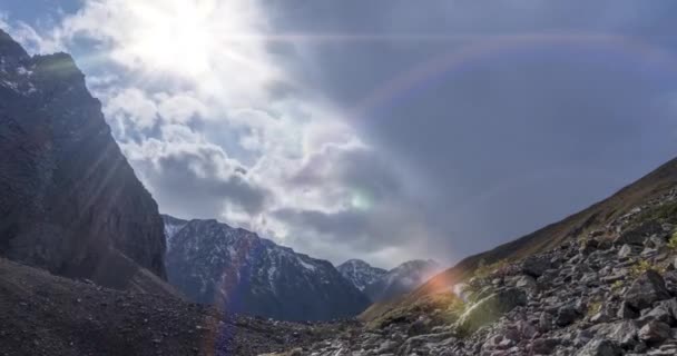 Timelapse van epische wolken in het bergdal in de zomer of herfst. Wilde eindeloze natuur en sneeuwstorm lucht. Zonnestralen boven de sneeuwtop — Stockvideo
