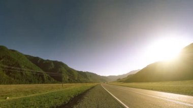Yaz ya da sonbahar günbatımında gün batımında dağ yolu zamanı. Vahşi doğa ve kırsal alan.