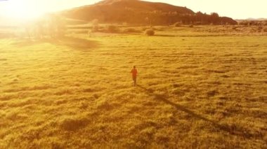 Mükemmel yeşil çayır üzerinde uçan bir sporcu. Dağda gün batımı