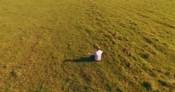 Lavt kretsløp rundt mennesket på grønt gress med notisbok på gult landskap. – stockvideo