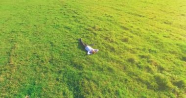 Yeşil çimlerin üzerinde sarı kırsal alanda not defteri olan bir adamın etrafında alçak yörünge uçuşları..