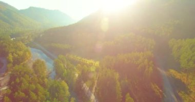 Güneşli yaz sabahında kayalarla birlikte taze, hızlı dağ nehri üzerinde alçak irtifa uçuşu..