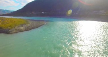 Güneşli yaz sabahında kayalarla birlikte taze, hızlı dağ nehri üzerinde alçak irtifa uçuşu..