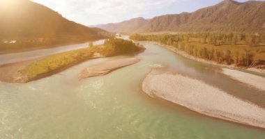 Güneşli yaz sabahında kayalarla birlikte taze, hızlı dağ nehri üzerinde alçak irtifa uçuşu..
