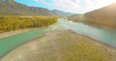 Güneşli yaz sabahında kayalarla birlikte taze, hızlı dağ nehri üzerinde alçak irtifa uçuşu..