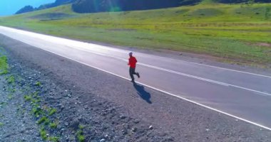 Mükemmel asfalt yolda sporcunun önünde alçak irtifa uçuşu.