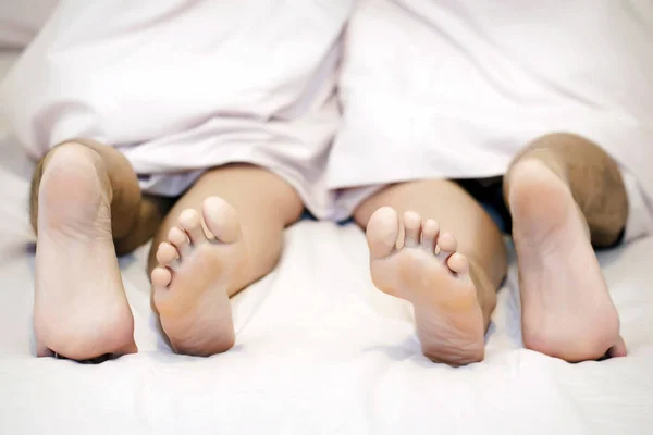 ベッドの上で男性と女性の足のクローズ アップ — ストック写真