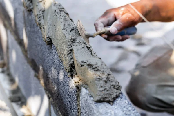 Mason plastering the concrete to build wall