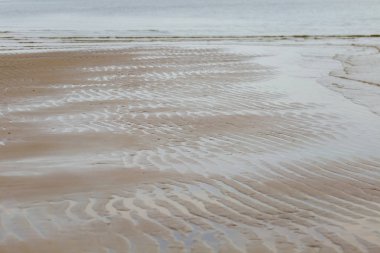 Kumlu sahilde denizin yumuşak dalgası