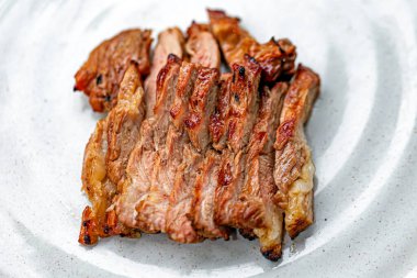 Marul yatağında ızgara domuz budu dilimleri.