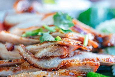 Marul yatağında ızgara domuz budu dilimleri.