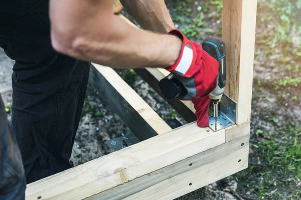 Holzschuppenbau Mann Schraubt Eckgelenkstrebe — Stockfoto