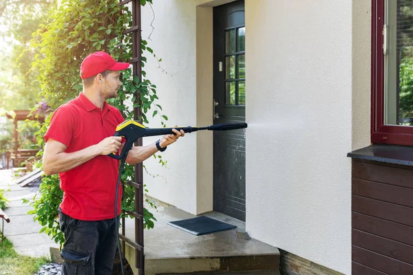 Arbeiter Mit Hochdruckreiniger Reinigt Hausfassade lizenzfreie Stockfotos