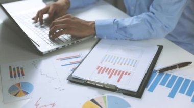 İş Analizi - finansal veriler çizelgeler ve grafikler ile ofiste çalışan adam