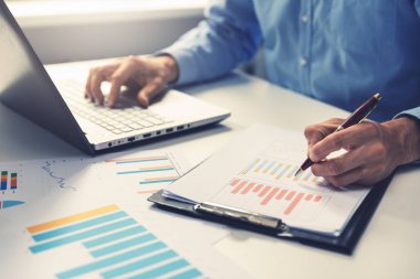Ofis Masası dizüstü bilgisayar kullanarak yıllık iş raporu analiz işadamı