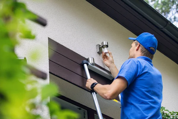 Elektriker Stående Stege Och Ändra Glödlampan Huset Fasaden Lampa — Stockfoto