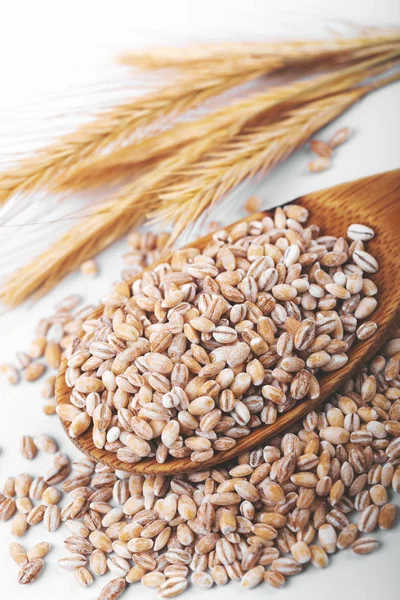 pearl barley in wooden spoon